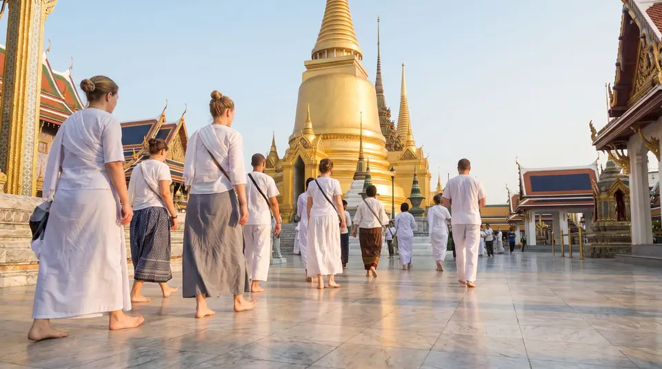 Visitors in modest clothes crossing a temple courtyard